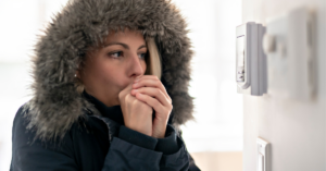 woman wearing winter coat in freezing home