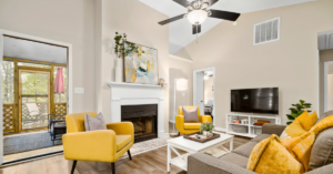 large modern living room with a grey couch and yellow chairs and pillows