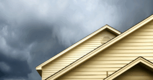 Thunderstorm approaching a yellow house.