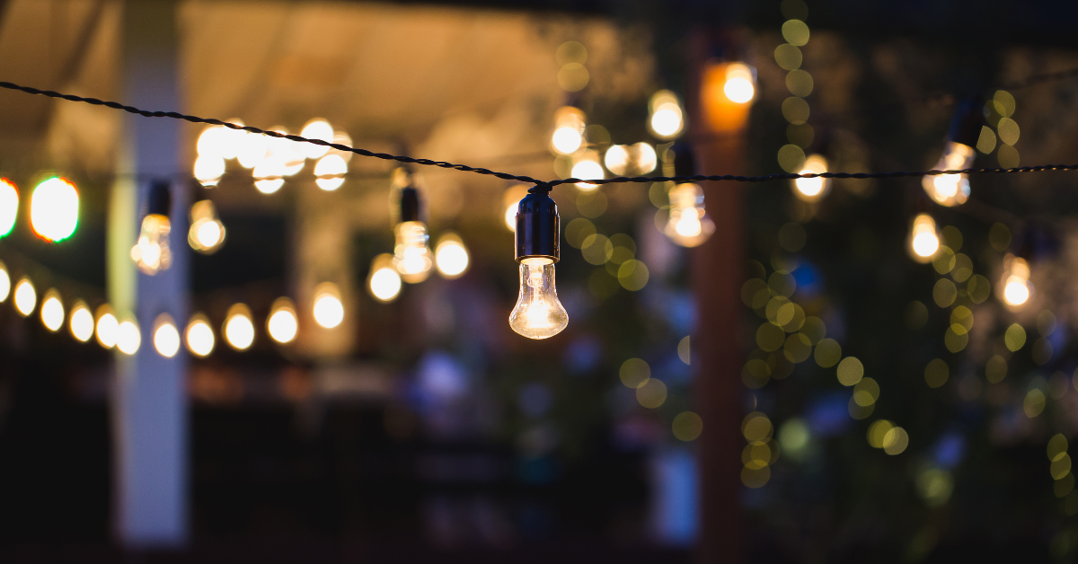 Outdoor string lights at night hanging outside of a home