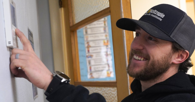 Holtzople technician Bayley installing a thermostat