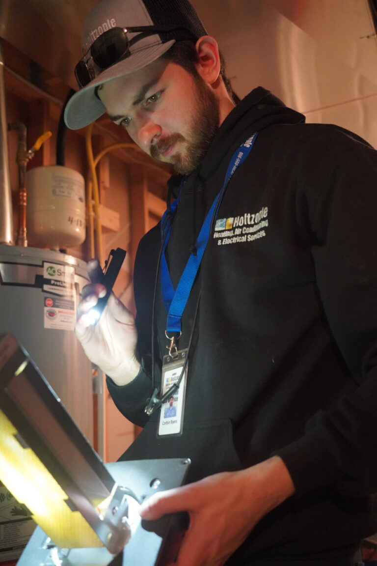Holtzople service technician Corbin holding a UV light